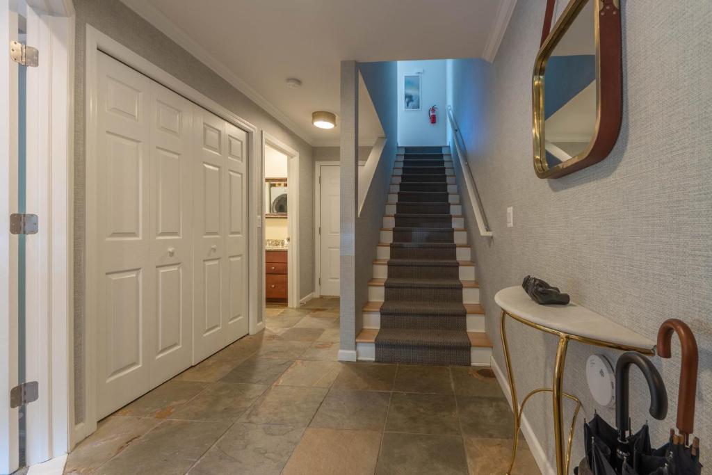 a hallway with a white door and a staircase at Butler Street Condo #16 - Walking Distance to downtown Saugatuck - Newer vacation rental in Saugatuck