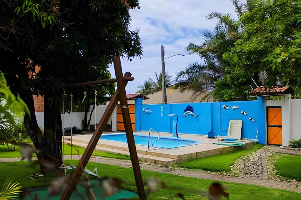 une aire de jeux avec un mur bleu avec une piscine dans l'établissement Casa na ilha da Crôa, à Barra de Santo Antônio