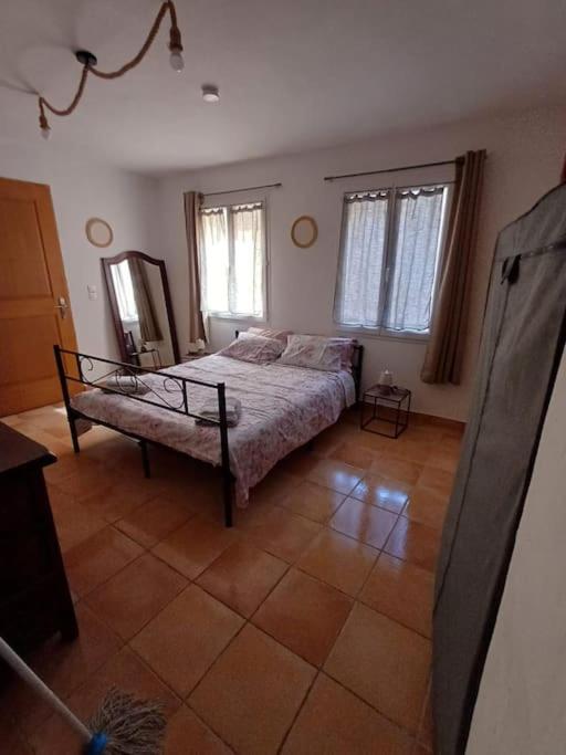 une chambre avec un lit et deux fenêtres dans l'établissement maison de village, à Montferrat