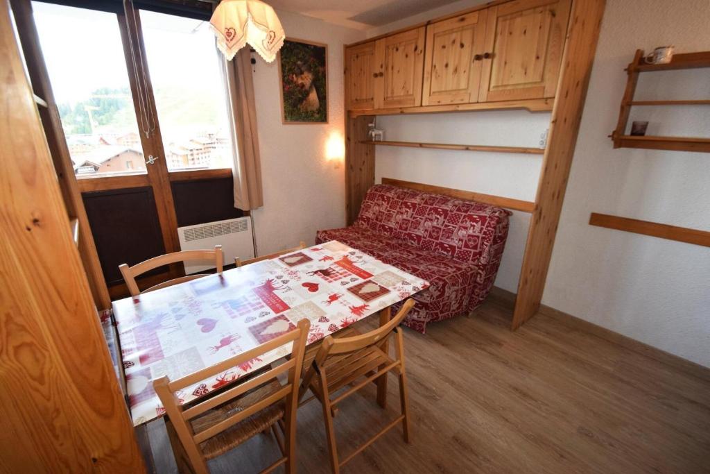 Cette petite chambre comprend une table, des chaises et un canapé. dans l'établissement Résidence Les Hameaux I - Studio 3/4 pers - LES HAMEAUX 1 - PLAGNE VILLAGES MAE-9374, à Aime La Plagne