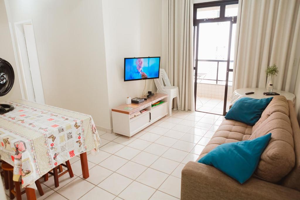 MuquiçabaにあるApto a 190m do mar da Praia do Morro -Guarapari ESのソファとテレビのあるリビングルーム