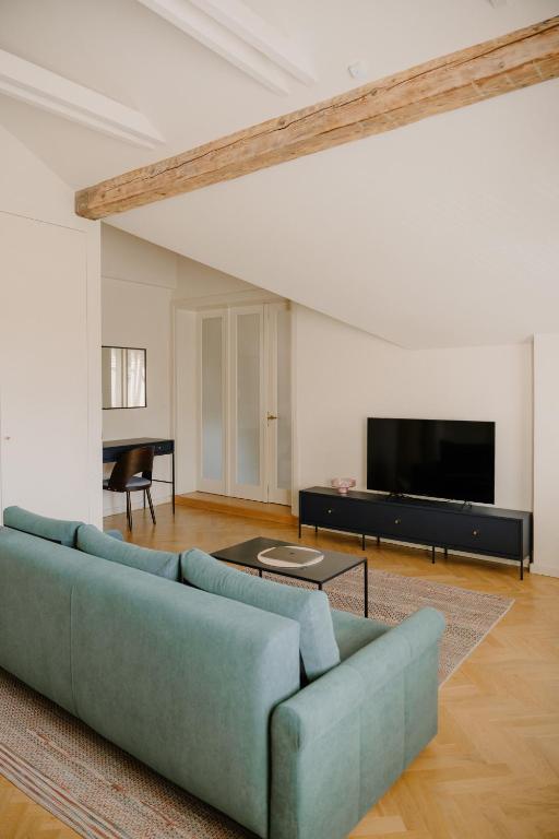 a living room with a blue couch and a flat screen tv at APARTAMENT OSIEM OSIEM w CENTRUM in Nowy Sącz
