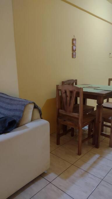 a living room with a table and a chair at Apartamento confortável, central na Avenida in Uruguaiana