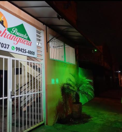 a building with a palm tree in front of it at Pousada Anhanguera in Ribeirão Preto