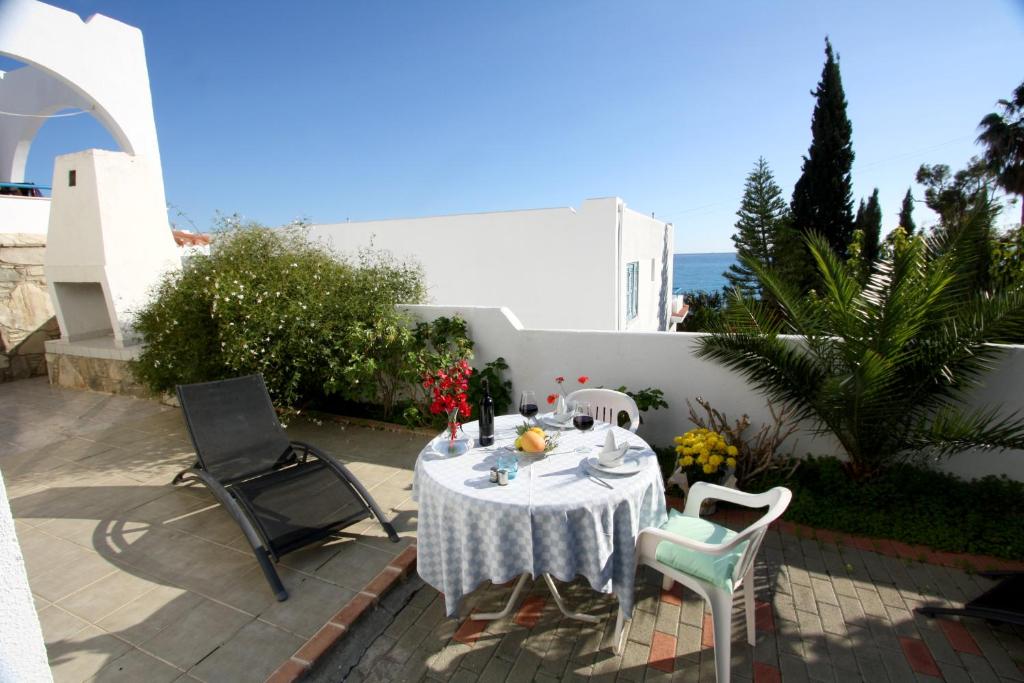 a table with a white table cloth and chairs on a patio at Pissouri Beach Apartments in Pissouri