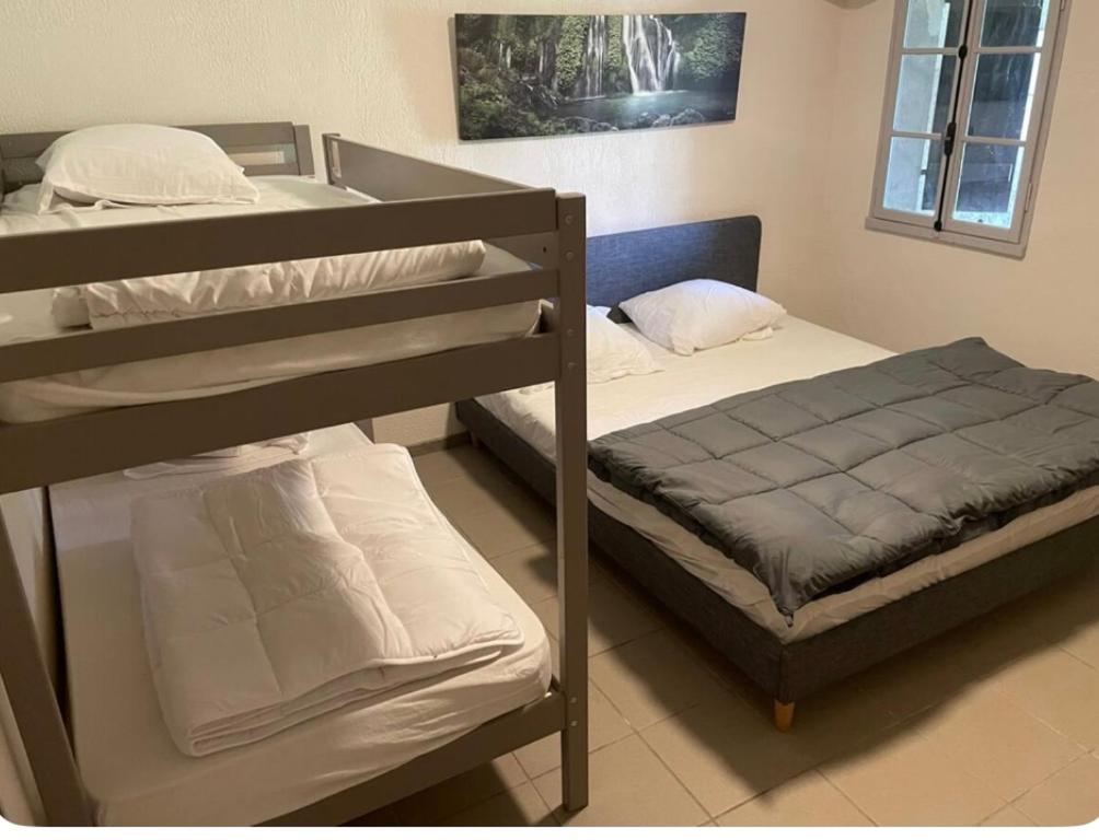 - une chambre avec deux lits superposés et un couvre-lit dans l'établissement L escapade nature, à Saint-Brès