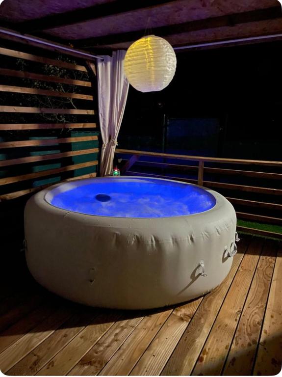 une grande baignoire assise sur une terrasse en bois dans l'établissement Carine et Alex, à Saint-Brès