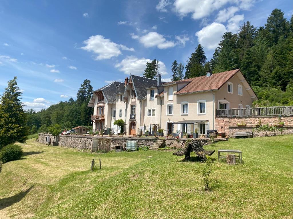 una grande casa su una collina con un cortile di Le Grimaubois a Hurbache