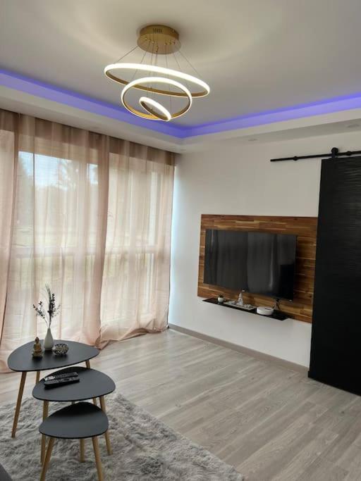 ein Wohnzimmer mit einem Tisch und einem Flachbildfernseher in der Unterkunft F2 à 12 mn de Paris avec Sauna - Parking privé in Argenteuil