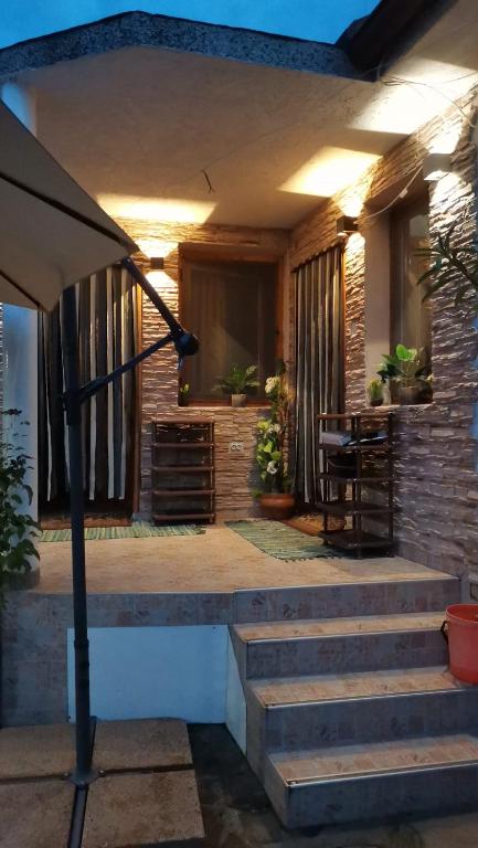 a house with a porch with stairs and a table at Guest house Nedyalkovi in Chernomorets