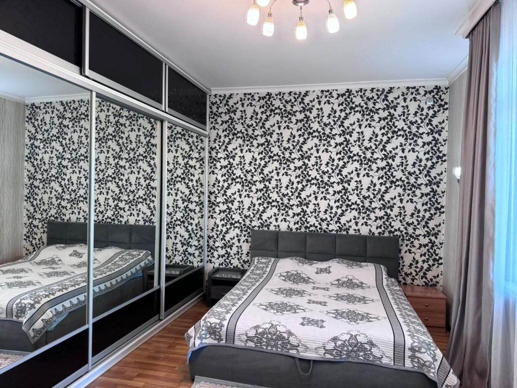 two beds in a bedroom with black and white wallpaper at Turmys hostel in Almaty