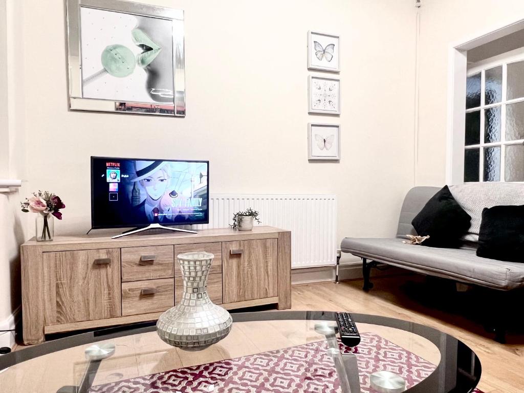 a living room with a tv and a couch at Cosy house Trafford Manchester in Manchester