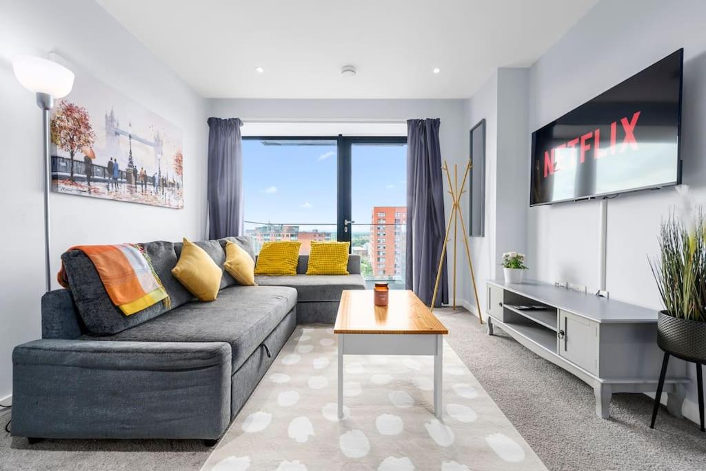 Una sala de estar con un sofá y un televisor. en Modern Apartment Central Manchester, en Mánchester
