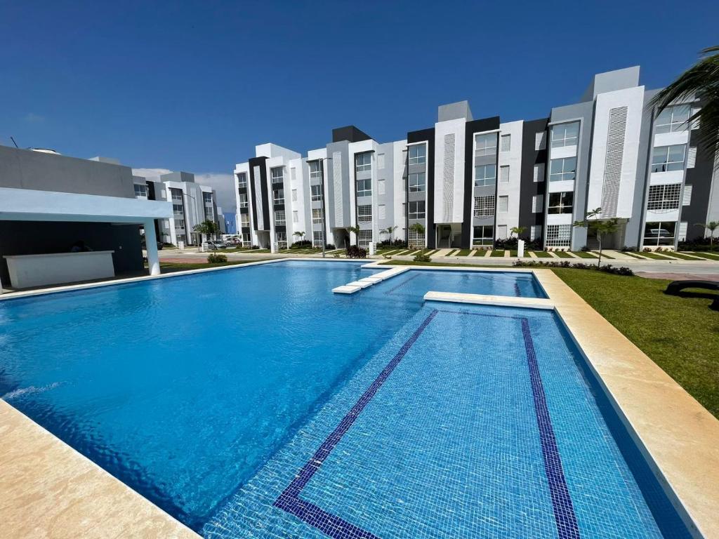 a swimming pool in front of a building at Departamento completo cerca del Mar in Gallinero