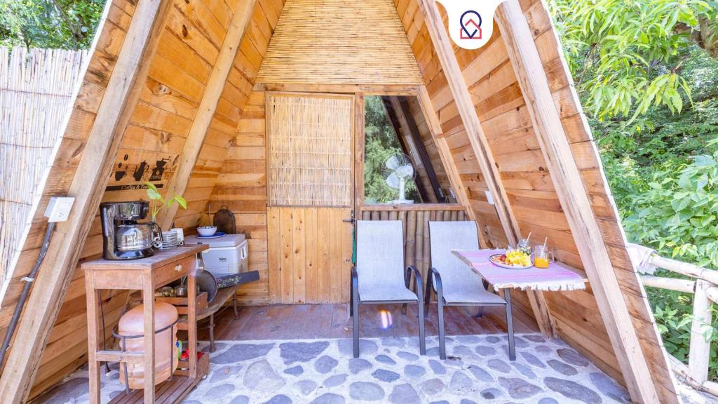 a wooden cabin with a table and chairs in it at New Natural Paradise Amazing Pet Friendly Cabin in Xoxocotla