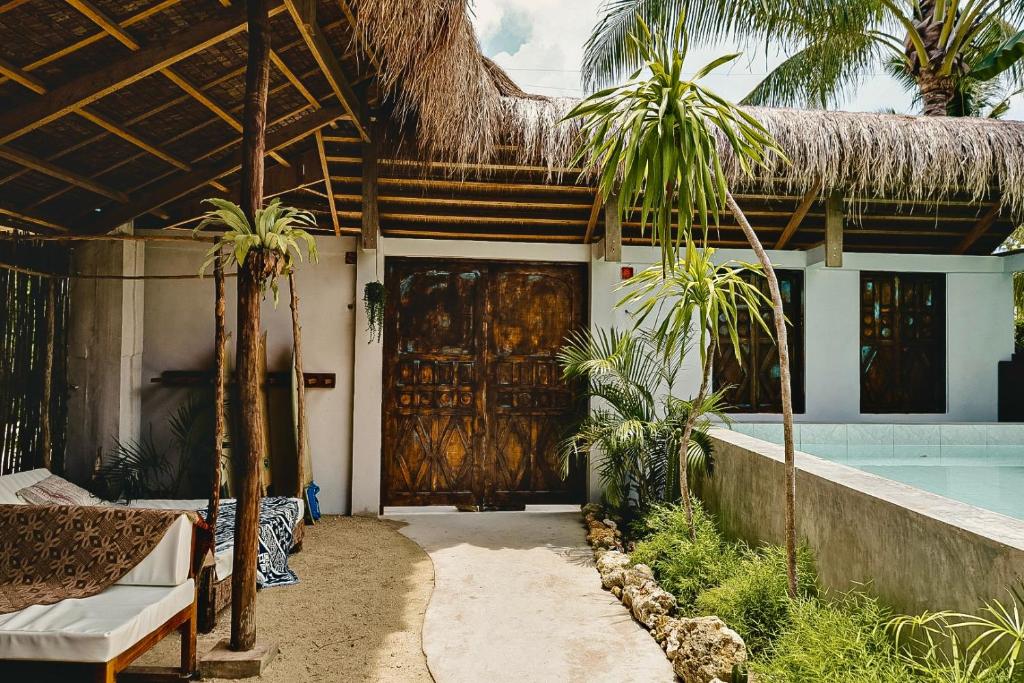 a house with a large wooden door and a swimming pool at La Bohème Boutique Glamping in General Luna