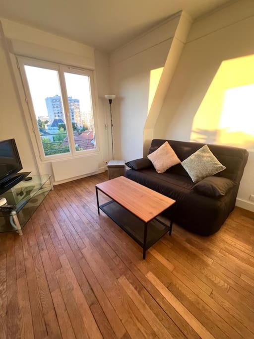 un salon avec un canapé et une table basse dans l'établissement Studio confortable proche Paris, à Châtillon