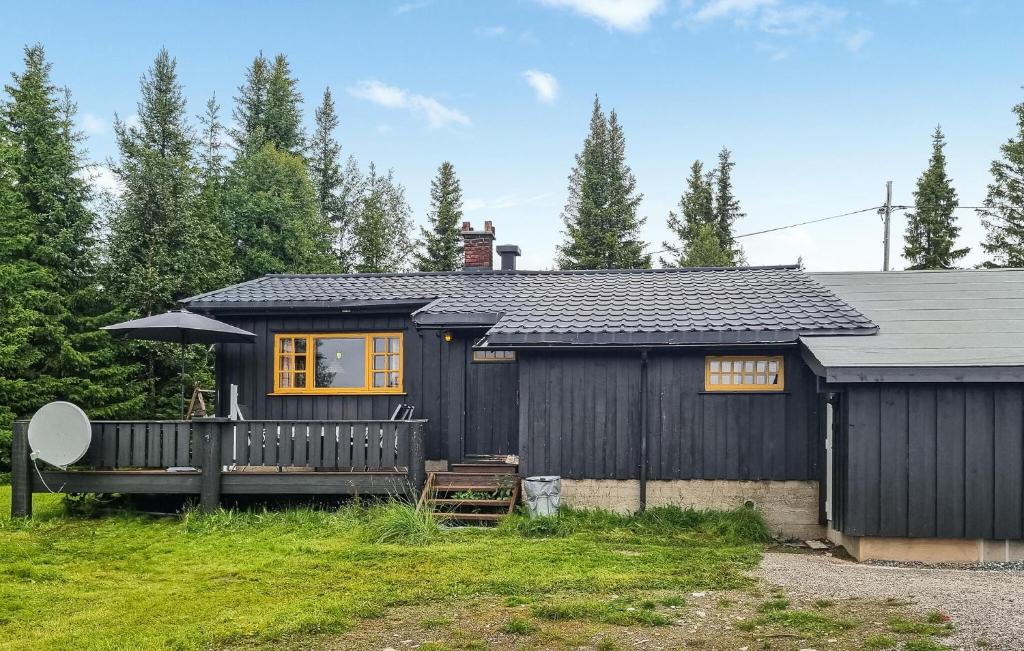 a black house with a porch and an umbrella at Månebu in Tunhovd