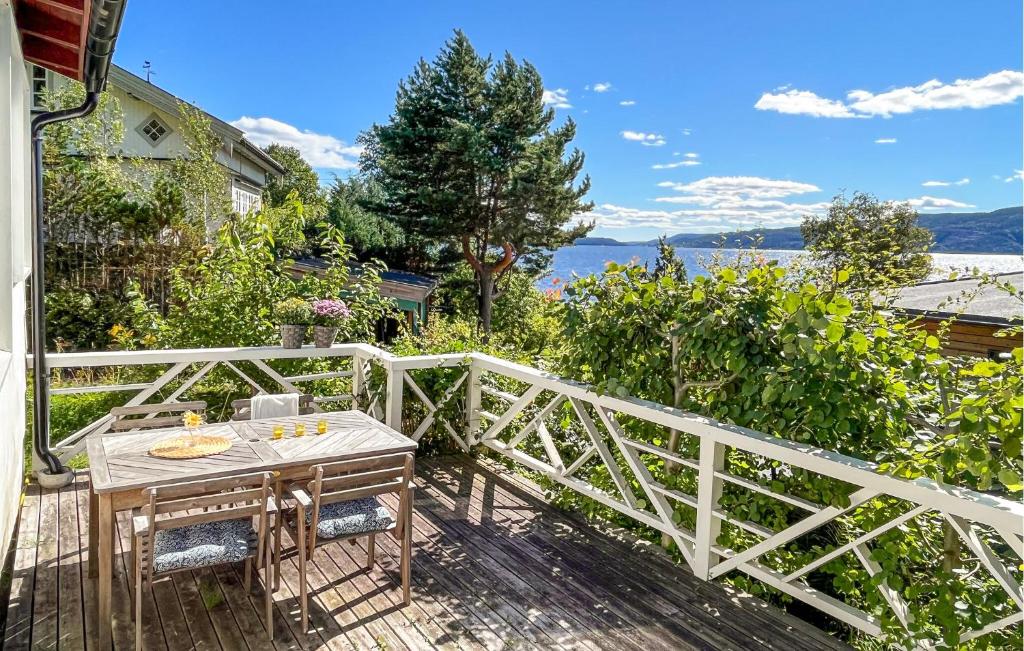 a wooden deck with a table and a white fence at Nice Home In Klokkarstua With Wifi in Ustad
