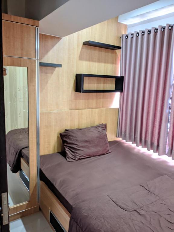 Una cama pequeña en una habitación con ventana. en Apato property the jarrdin, en Bandung