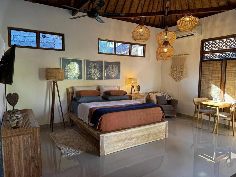 ein Schlafzimmer mit einem Bett und einer Couch darin in der Unterkunft Indah puri Bali Bungalow on Candidasa beach in Candidasa