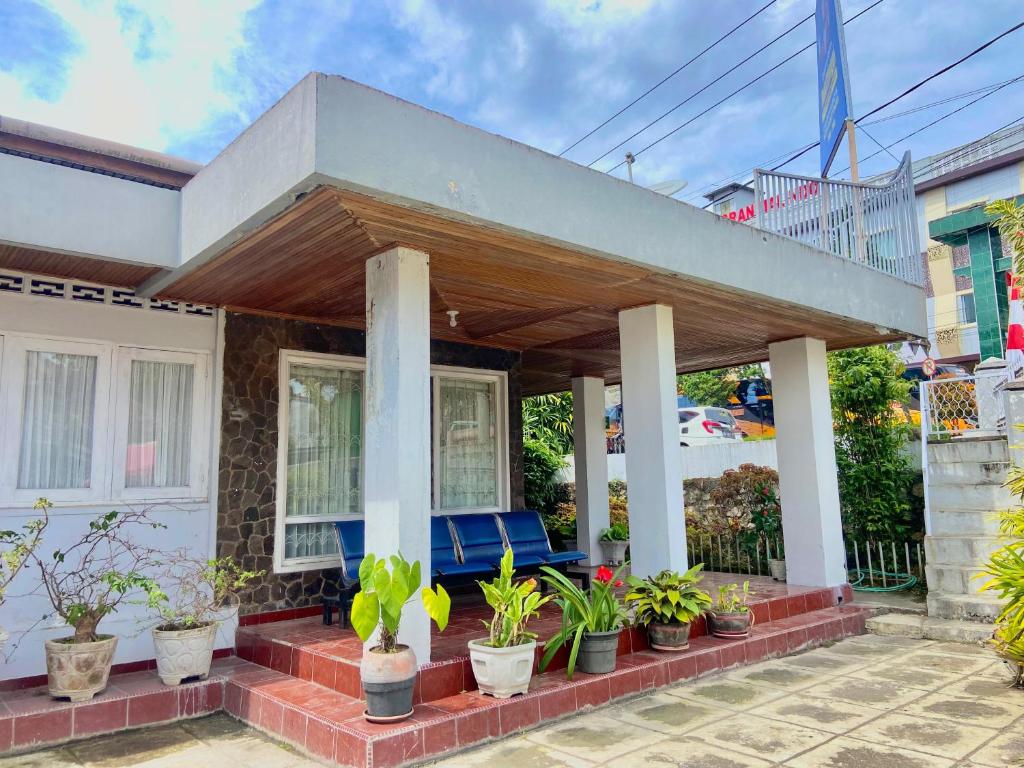 a porch of a house with potted plants at Nan kanduang Homestay in Bukittinggi