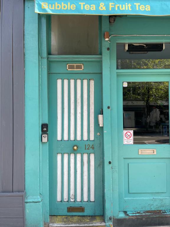 Una puerta turquesa de un edificio con una puerta azul. en Cosy Room4 in London Kings Cross, en Londres