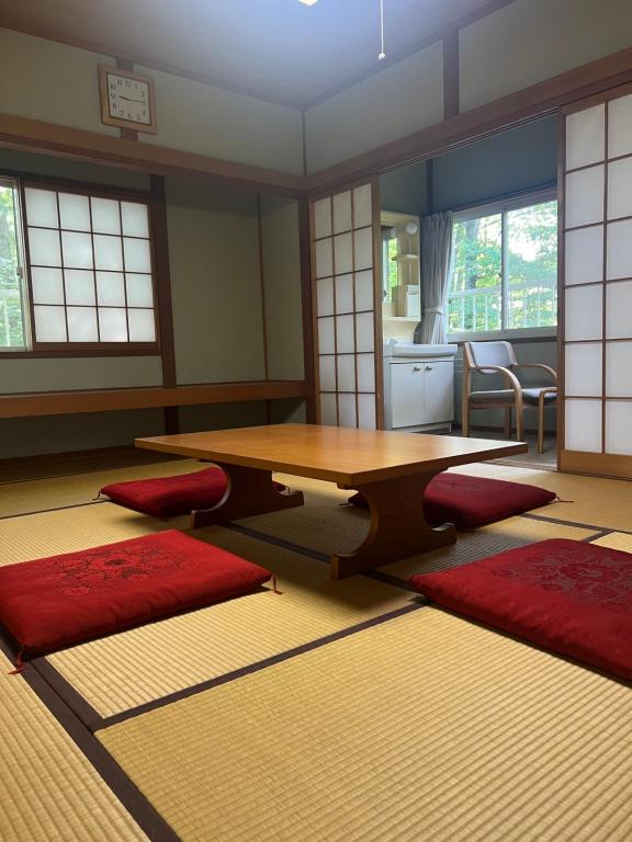 軽井沢町にある余裕堂軽井沢山荘のリビングルーム(木製テーブル、赤いマット付)