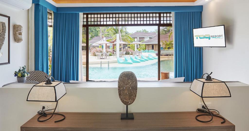 a room with two lamps and a window with a pool at Tag Resort in Coron