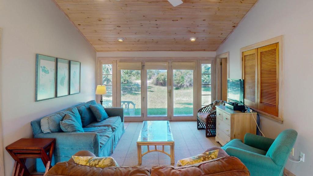 a living room with a blue couch and chairs at ALWAYS TURTLE CRAWL home in Jekyll Island