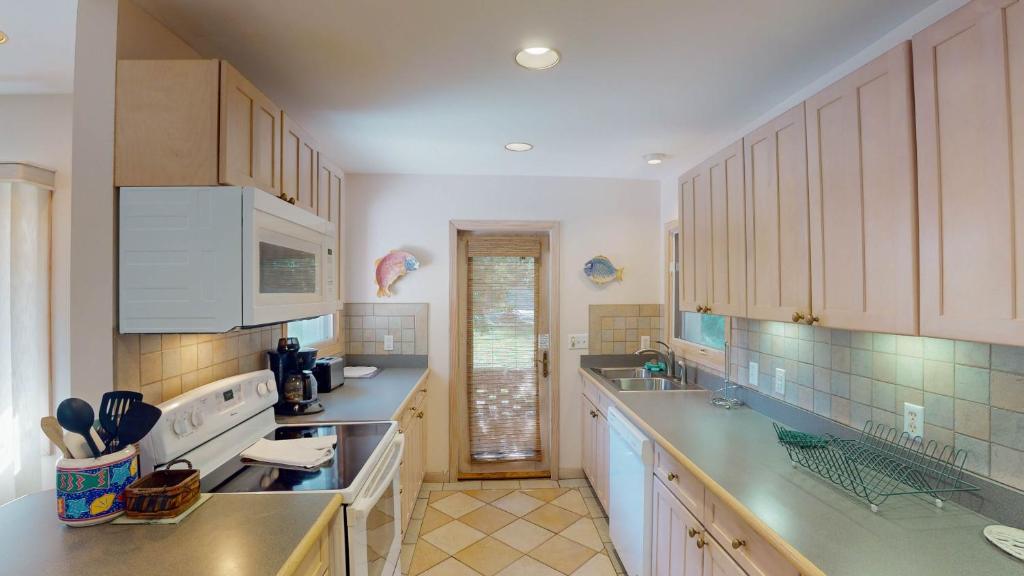 a kitchen with white cabinets and a counter top at ALWAYS TURTLE CRAWL home in Jekyll Island