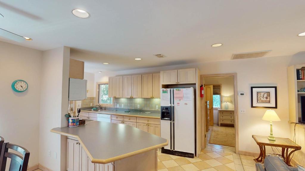 a kitchen with a refrigerator and a table in it at ALWAYS TURTLE CRAWL home in Jekyll Island