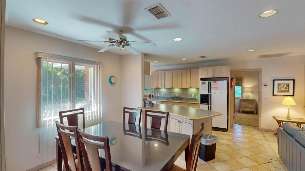 a kitchen with a dining table and a ceiling fan at ALWAYS TURTLE CRAWL home in Jekyll Island