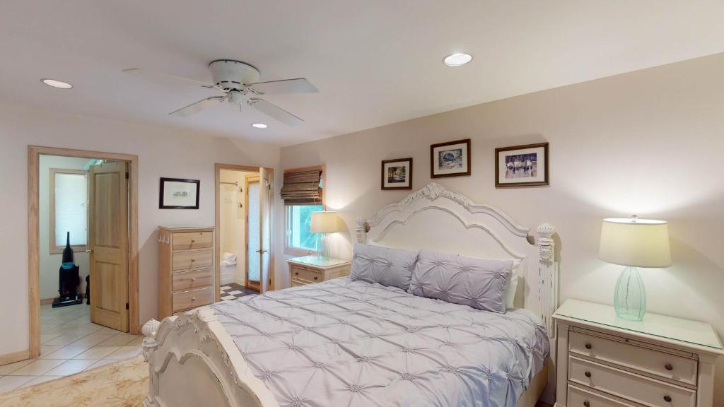 a bedroom with a bed and a ceiling fan at ALWAYS TURTLE CRAWL home in Jekyll Island
