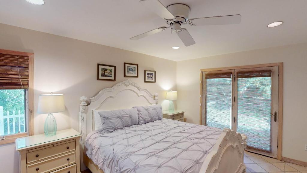 a bedroom with a bed and a ceiling fan at ALWAYS TURTLE CRAWL home in Jekyll Island