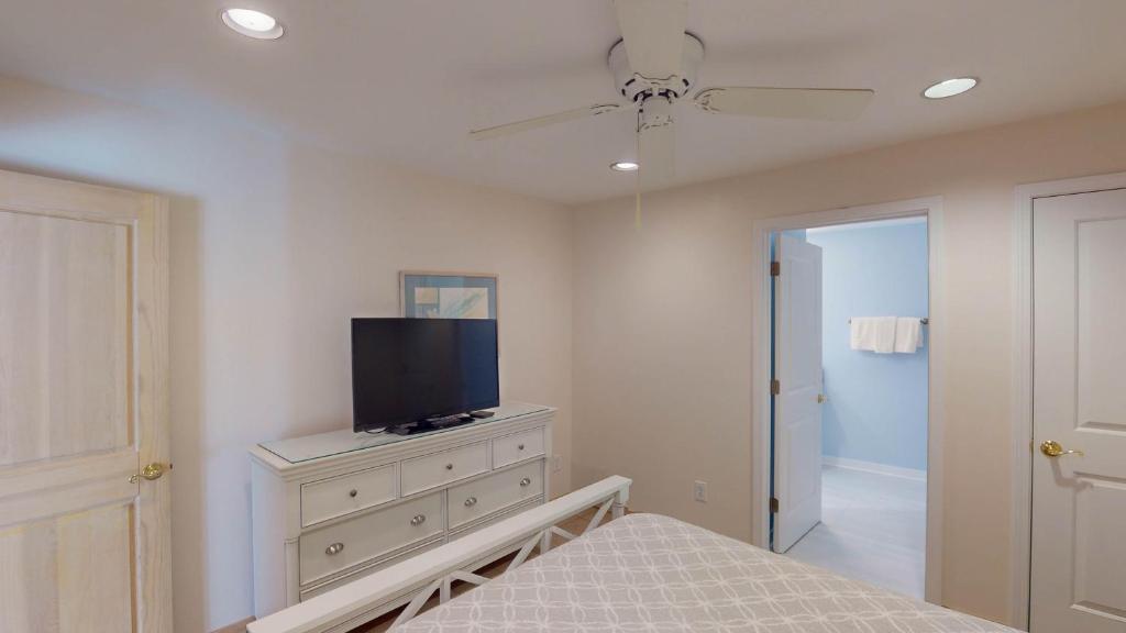 a bedroom with a bed and a television on a dresser at ALWAYS TURTLE CRAWL home in Jekyll Island