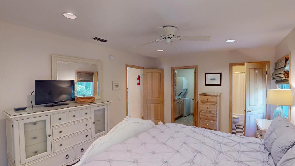 a bedroom with a bed and a flat screen tv at ALWAYS TURTLE CRAWL home in Jekyll Island