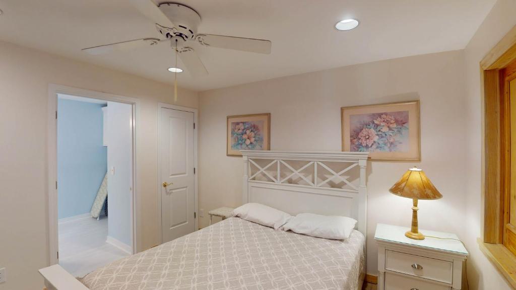 a bedroom with a bed and a ceiling fan at ALWAYS TURTLE CRAWL home in Jekyll Island