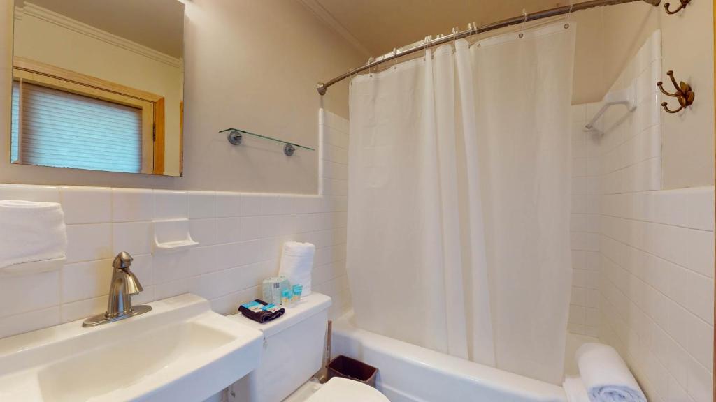 a white bathroom with a sink and a shower at ALWAYS TURTLE CRAWL home in Jekyll Island