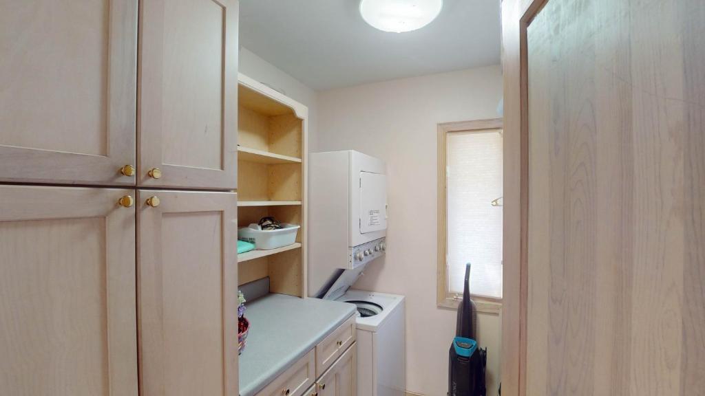 a small kitchen with white cabinets and a white appliance at ALWAYS TURTLE CRAWL home in Jekyll Island