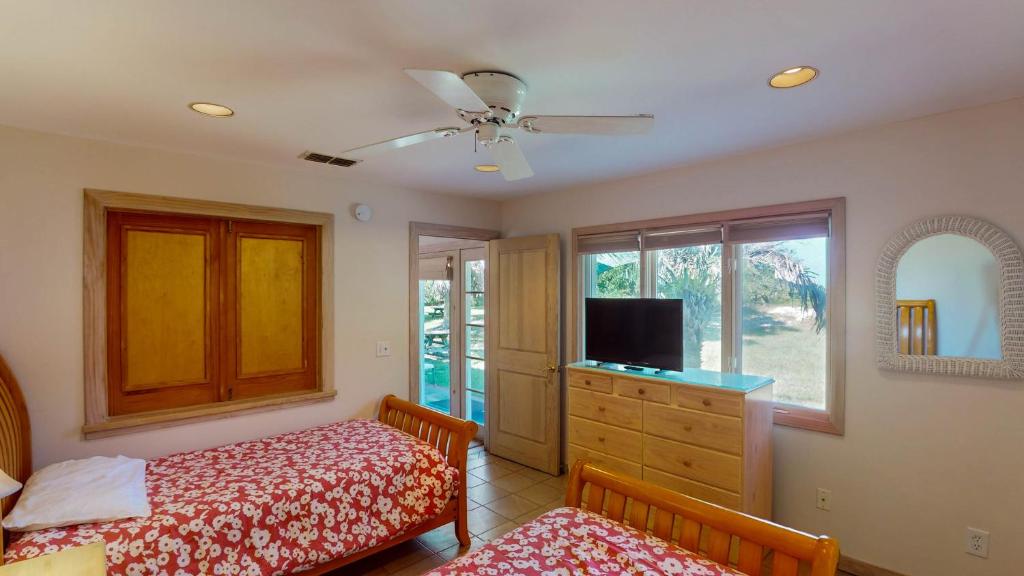 a bedroom with two beds and a flat screen tv at ALWAYS TURTLE CRAWL home in Jekyll Island