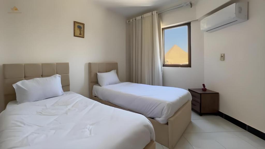 Ένα ή περισσότερα κρεβάτια σε δωμάτιο στο king ramses pyramids view apartment