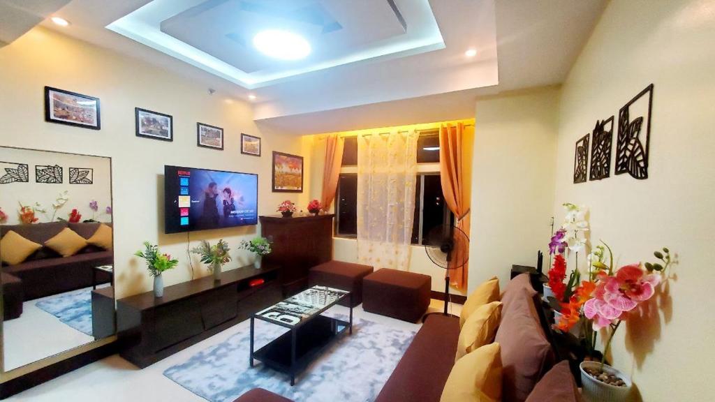 un salon avec un canapé et une télévision dans l'établissement One Manhattan Parkview, à Manille