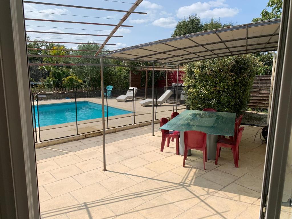 un patio avec une table et des chaises et une piscine dans l'établissement Maison de campagne, à Cieurac