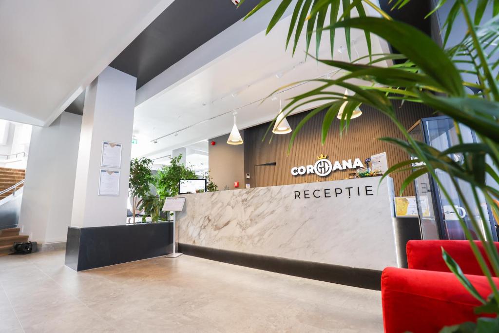 a reception area of a restaurant with a reception desk at Grand Hotel Coroana in Bistriţa