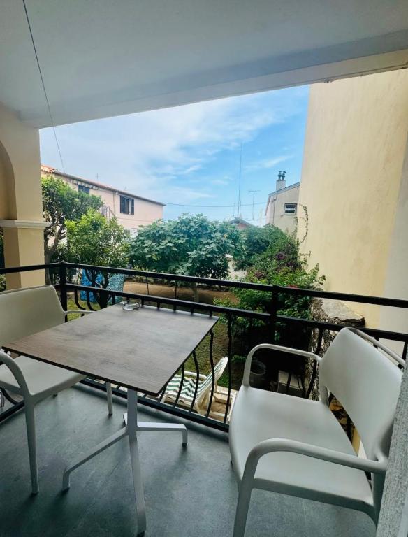une table et des chaises sur un balcon avec vue dans l'établissement LEî, à Beaulieu-sur-Mer