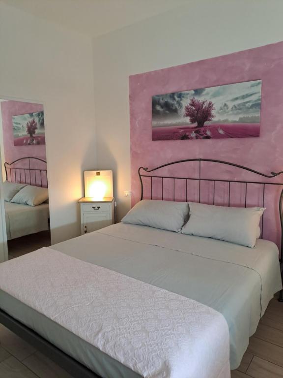 sypialnia z dużym łóżkiem i różowymi ścianami w obiekcie La casa dei butei w mieście Castelnuovo del Garda