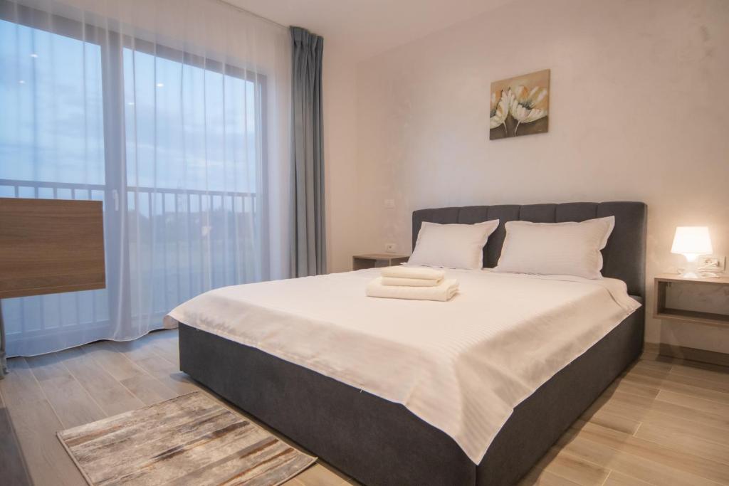 a bedroom with a large bed and a large window at CP Residence Apart in Braşov