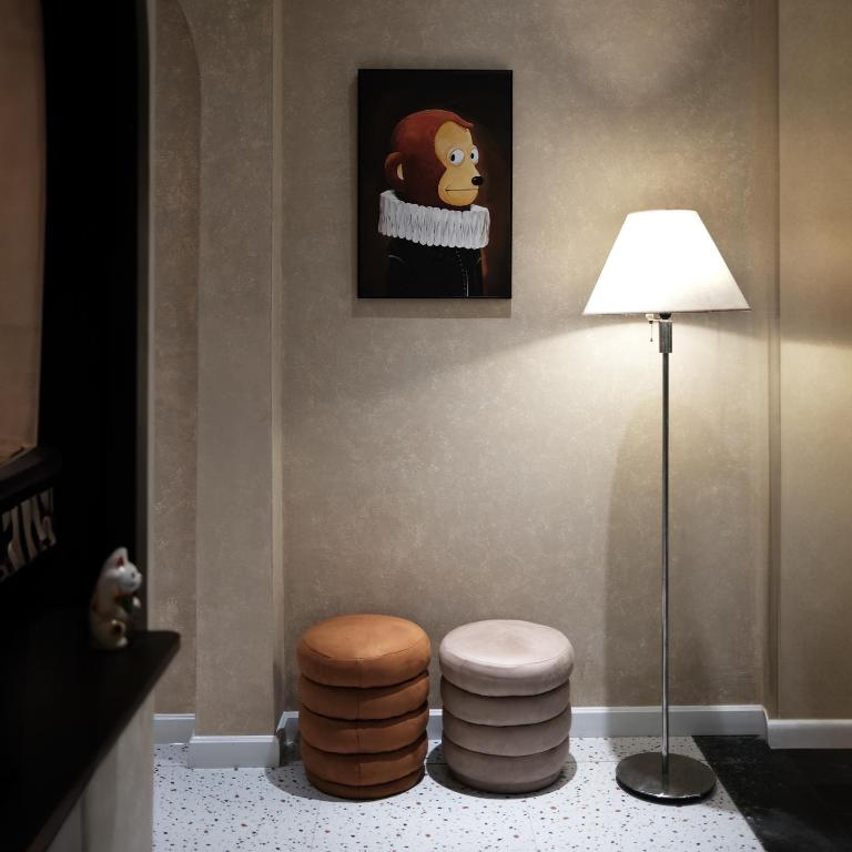 a room with two stools and a lamp and a painting at BenHouse Homestay in Ho Chi Minh City