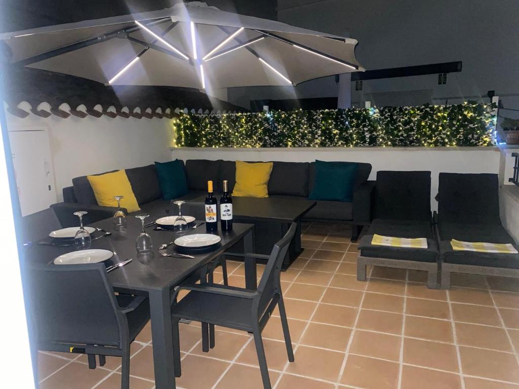 Un comedor con una mesa y un sofá. en Casa Emperador Penthouse, en Roldán